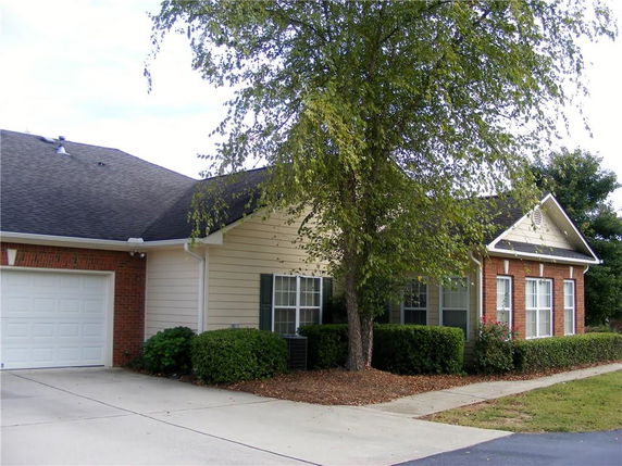 Front view of a single-story house with a garage and brick exterior.