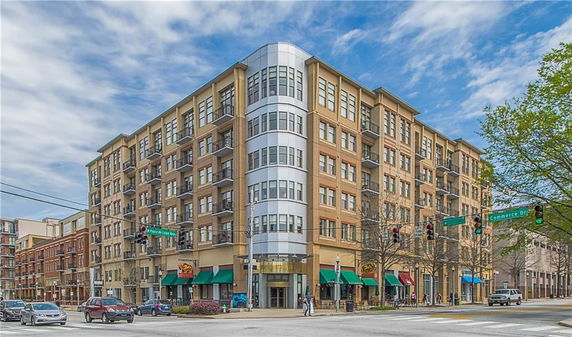 Front view of a multi-story building with commercial establishments on the ground floor.
