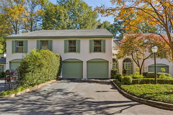Front view of a two-story house with green shutters and a three-car garage.