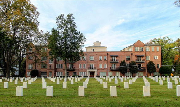 Front view of a multi-story brick building with balconies.