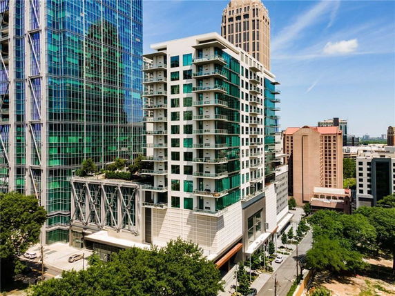Front view of a modern high-rise building with glass facade and balconies.