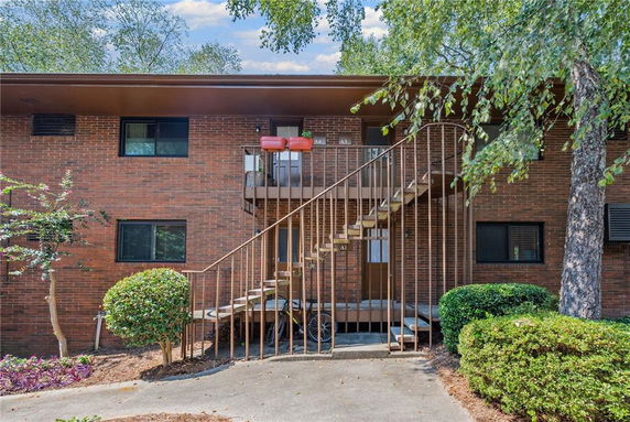 Front view of a two-story brick building with outdoor stairs leading to the upper level.