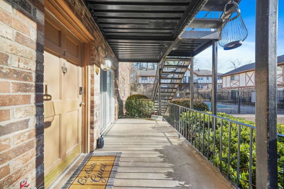 Exterior walkway of a brick apartment building with stairs.