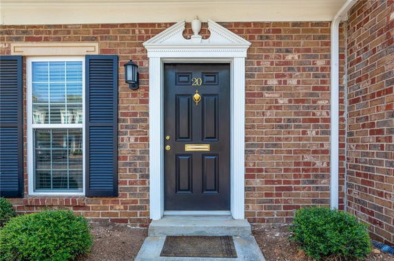 Front view of a house entrance with a black door and brick exterior.