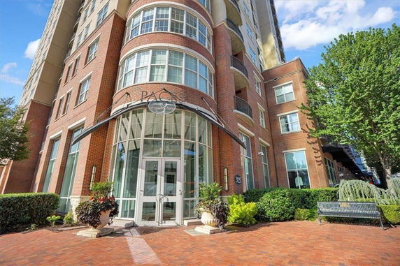 Front view of a multi-story brick building with large glass entrance.