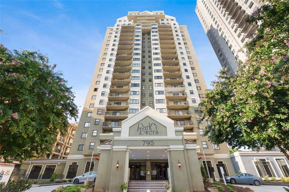 Front view of a high-rise residential building with multiple balconies.