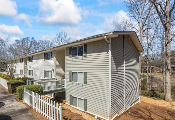 Front view of a multi-story building with vinyl siding and white trim.