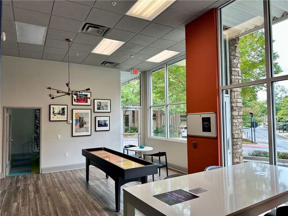 Interior view of a room with large windows and a game table.