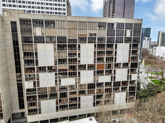 Front view of a multi-story building with numerous windows and balconies