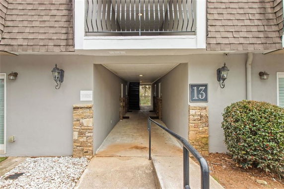 Front view of a building with stone accents and a central walkway leading inside.