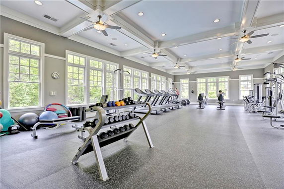 Interior of a gym facility with exercise equipment and large windows.