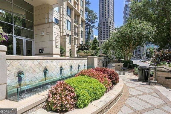 Front view of a multi-story building with landscaping and water features.