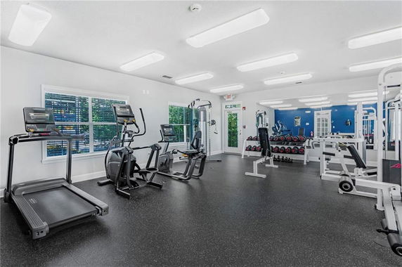 Interior view of a gym area with exercise equipment and weights.
