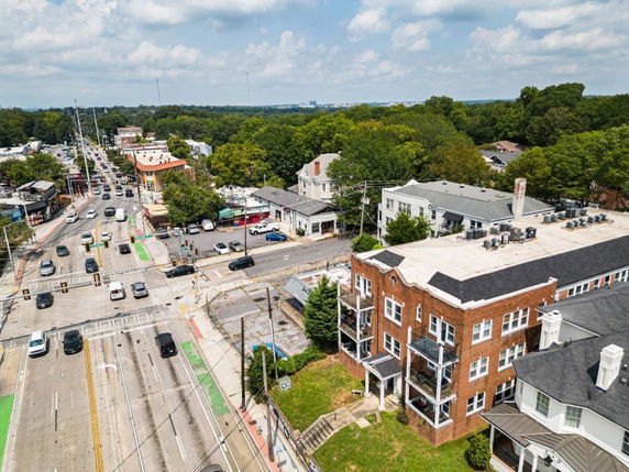 Aerial view of a multi-story brick building near a busy intersection with surrounding roads and cars.