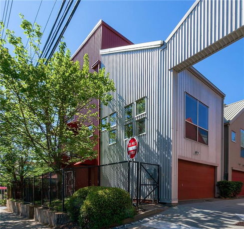 Front view of a modern building with metal siding and a garage door.
