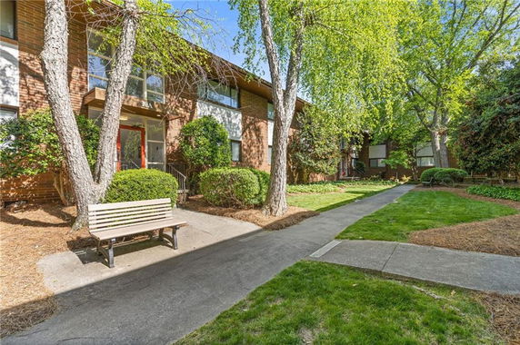 Front view of a brick residential building with a pathway and entrance.