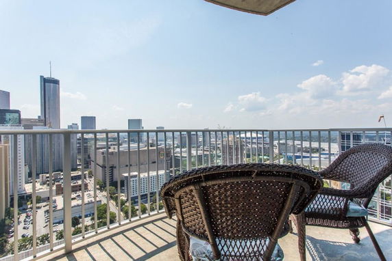 Wide-angle view from a balcony overlooking a cityscape with tall buildings.