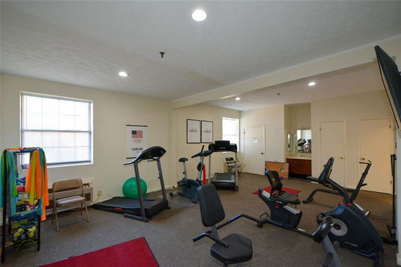 Indoor gym area with exercise equipment and bright lighting.