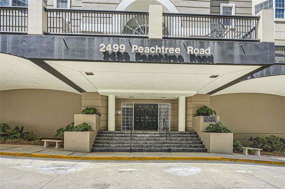 Front view of building entrance with stairs and address sign.