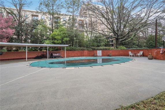 Outdoor swimming pool area with protective cover and seating.