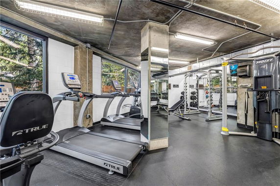 Indoor gym area with various exercise equipment including treadmills and weight machines.