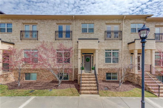 Front view of a multi-story townhouse with brick exterior and small front steps.