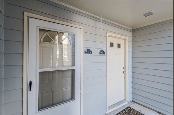 Front view of a house entrance with a white door and a storm door.