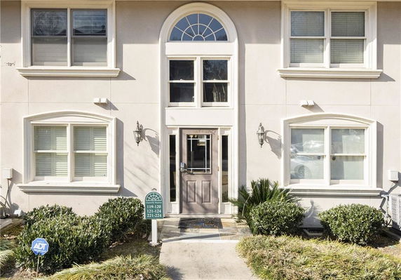 Front view of a two-story building with arched windows and a central entrance.