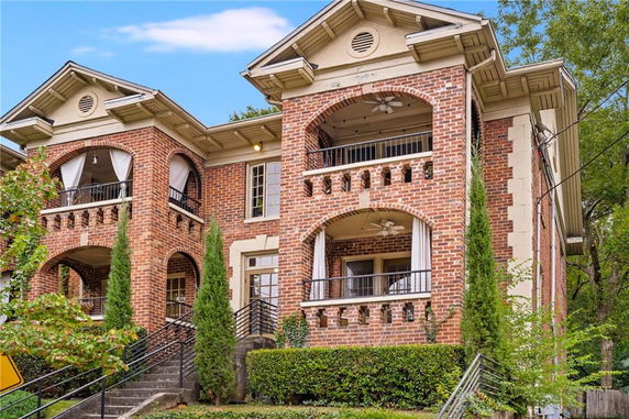 Front view of a two-story brick house with multiple balconies.