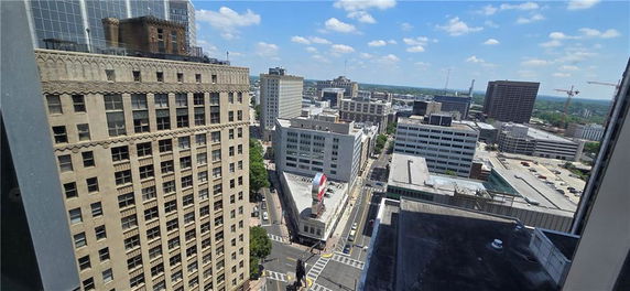 Panoramic view of a cityscape with multiple tall buildings observed from a high vantage point.
