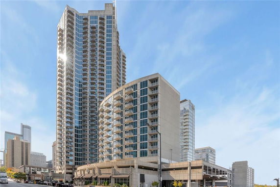 Front view of a tall, modern high-rise building with multiple balconies.