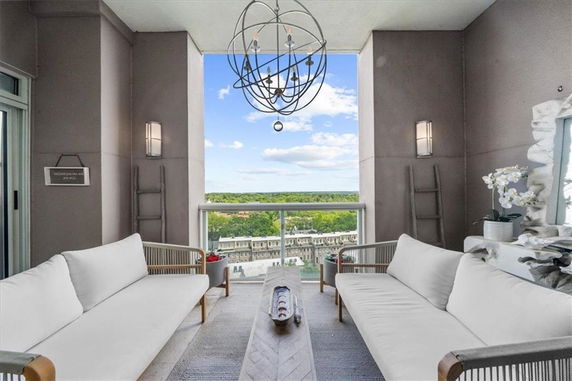 Balcony with modern seating set and a panoramic view of surrounding buildings.