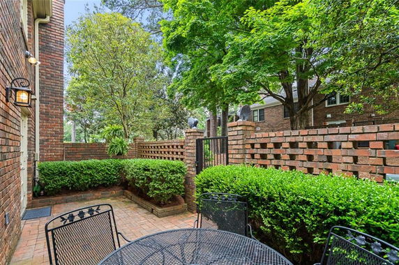 Brick-lined courtyard with outdoor seating and surrounding greenery.