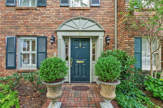 Front view of a house with a brick exterior and a dark green door.