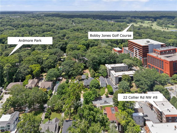 Wide aerial view of residential and commercial areas surrounded by greenery.