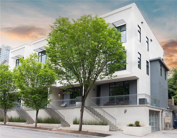 Front view of a modern multi-story building with large windows and staircase entrance.