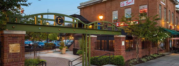 Front view of a commercial brick building with an arched entrance and signage.