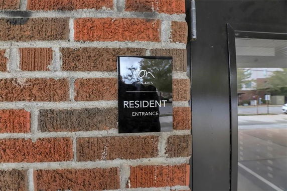 Close-up view of a brick wall with a resident entrance sign.