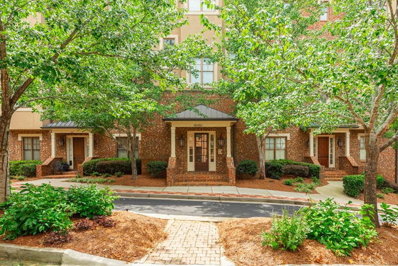 Front view of a brick townhouse with a small porch and entrance.