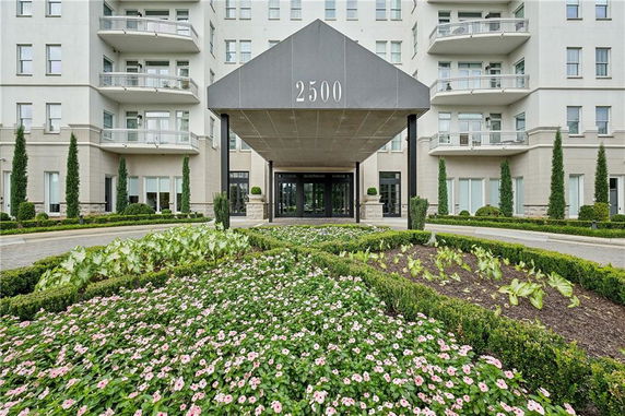 Front view of a multi-story building with balconies and an entrance canopy.