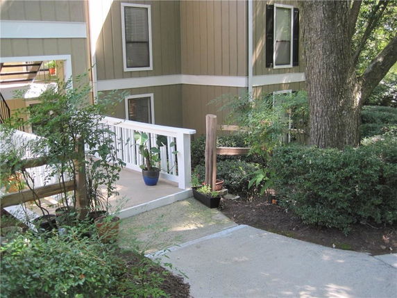 Front view of a residential building with a ramp and railing.