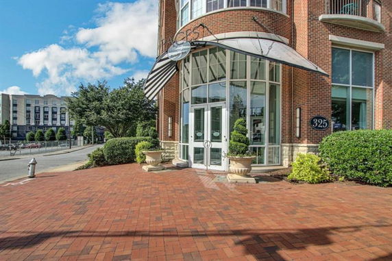 Front entrance of a brick building with large windows and glass doors.