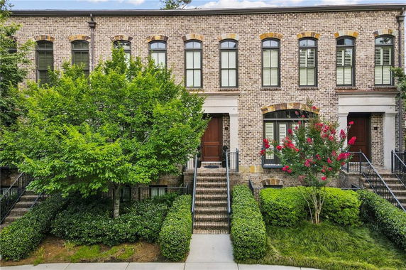 Front view of a brick townhouse with multiple windows and a centered entrance.