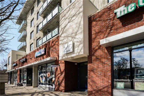 Front view of a multi-story building with brick facade and balconies.