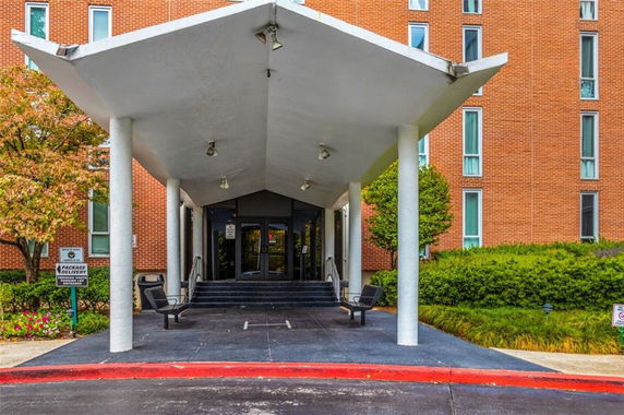 Front view of a building entrance with a canopy and steps leading to the door.