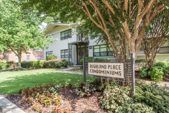 Front view of a condominium building with signage reading 'Highland Place Condominiums.'