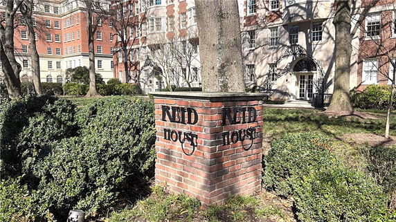 Front view of a multi-story brick building with a decorative entrance.