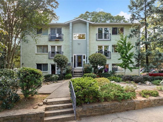 Front view of a three-story residential building with balconies.