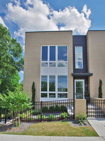 Front view of a modern two-story house with large windows and a brick exterior.