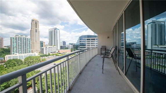Panoramic view from a balcony overlooking a cityscape with tall buildings.